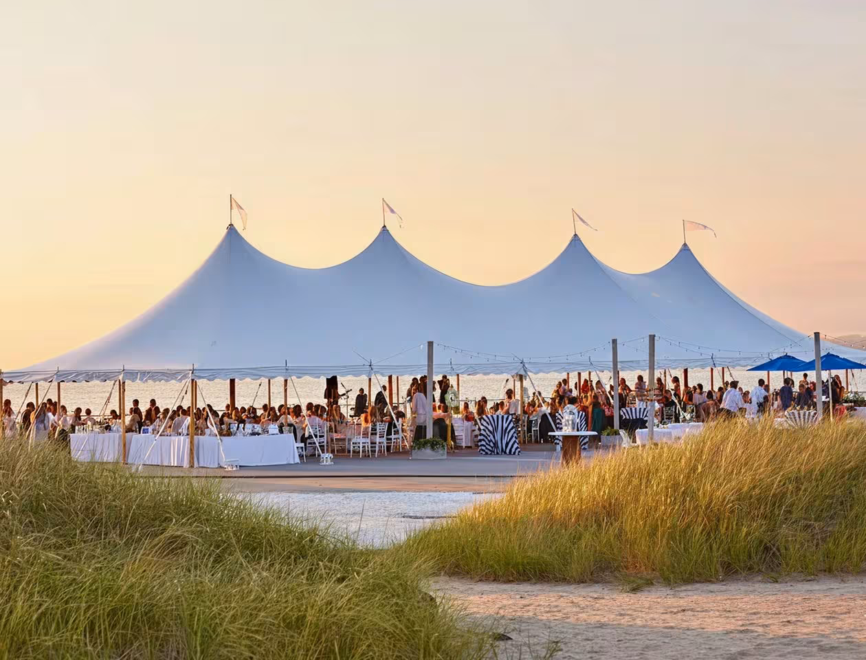 Large white stretch tent installed on a sandy beach for an outdoor event