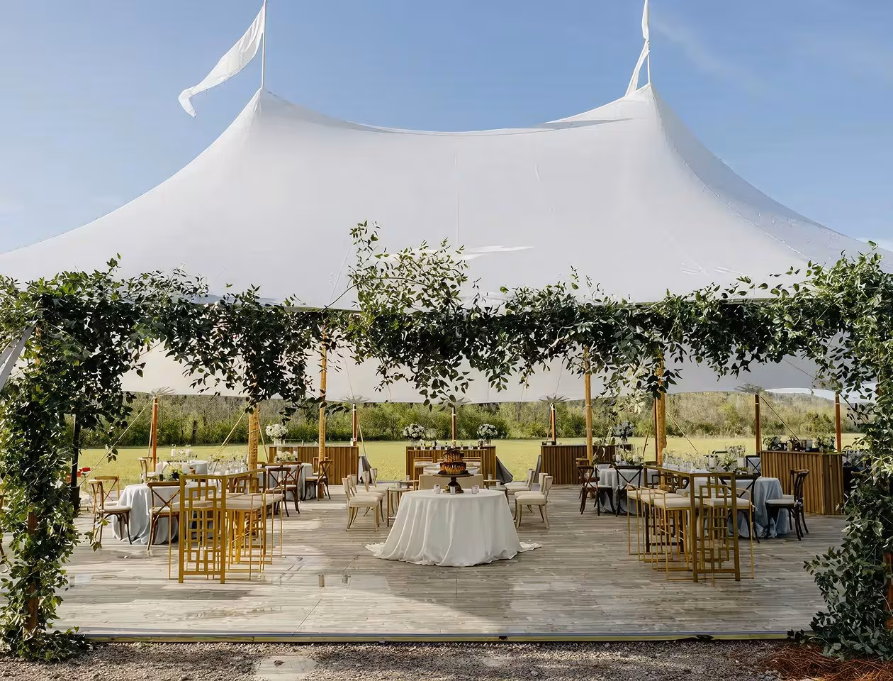 White stretch tent set up for a wedding reception with guest tables