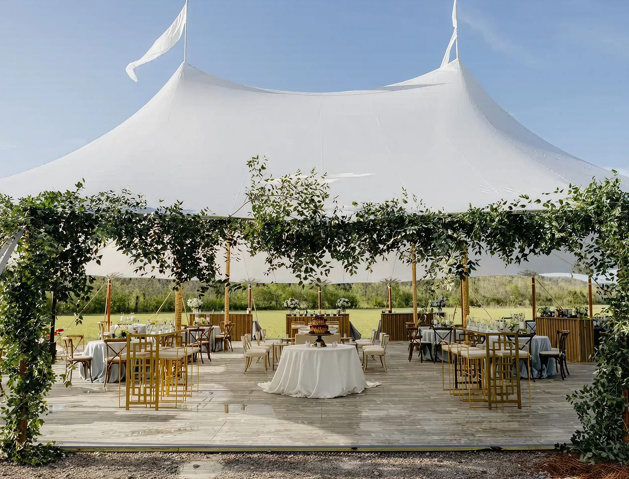 White stretch tent set up for a wedding reception with guest tables